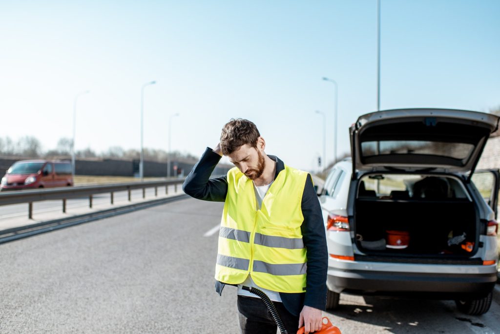 Man with refuel canister on the roadside